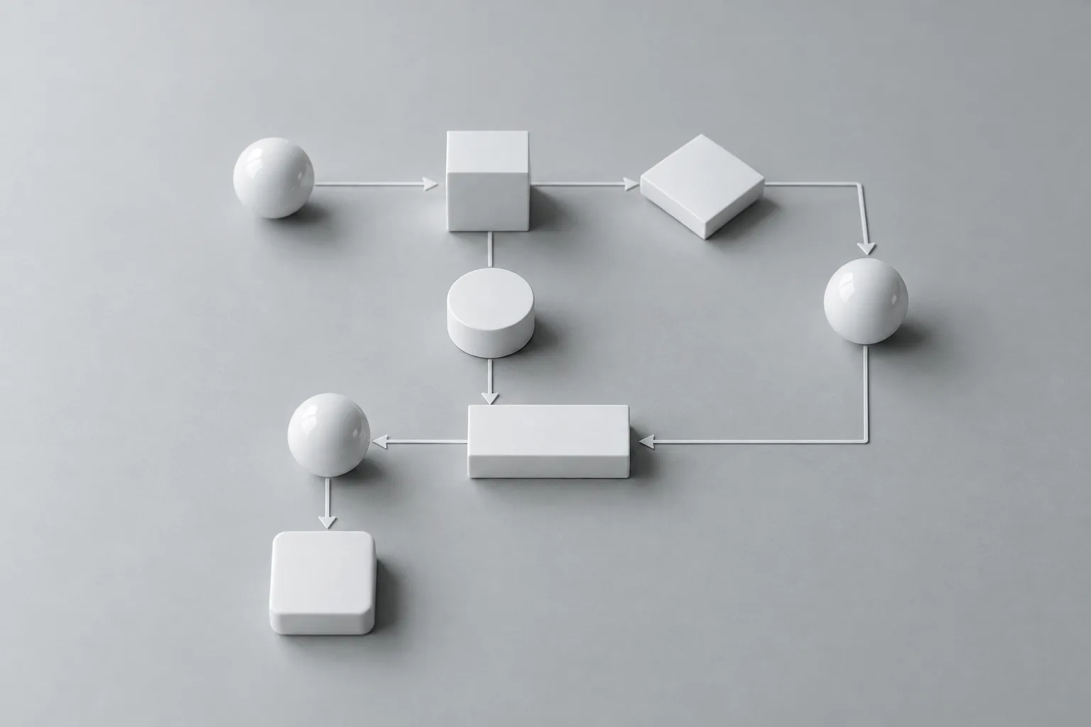 White blocks and spheres laid out as a flowchart with arrows on a grey table